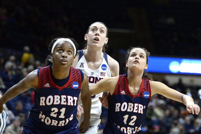 Connecticut’s Breanna Stewart, center, and Robert Morris’ Mikalah Mulrain, left, and Lou Mataly, right, look for a rebound during the NCAA Tournament last March.