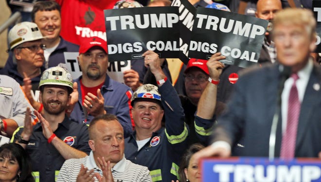 Coal miners wave signs as Republican presidential candidate Donald Trump speaks during a rally in Charleston, W.Va., on May 5. Trump's election could signal the end of many of President Barack Obama's signature environmental initiatives. Trump has said he loathes regulation and wants to use more coal and expand offshore drilling and hydraulic fracturing. AP Photo/Steve Helber, File