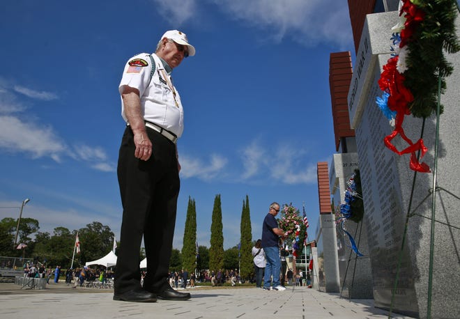 Korean War Veteran Bill Barton reads the names of the fallen soldiers engraved on the World War II monument during the annual Veteran's Day Memorial on Friday at Veterans Memorial Park In Gainesville. (Andrea Cornejo/ Staff photographer)
