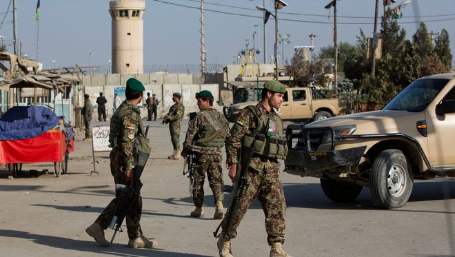 Afghanistan’s National Army soldiers guard, blocking the main road to the Bagram Airfield’s main gate in Bagram, north of Kabul, Afghanistan, Saturday, Nov. 12, 2016. An explosion at a U.S. airfield in Afghanistan early Saturday killed four people, the head of international forces in the country said. (AP Photos/Massoud Hossaini)