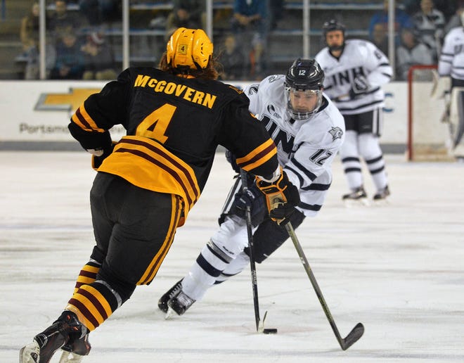 New Hampshire's Shane Eiserman moves the puck past Arizona State's Ed McGovern during Saturday's game at the Whittemore Center in Durham.

Photo by Drew Hallett/Fosters.com