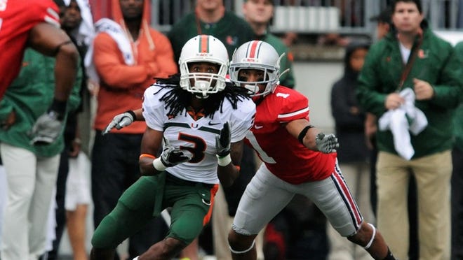 COLUMBUS, OH - SEPTEMBER 11: Travis Benjamin #3 of the Miami Hurricanes receives a pass as Devon Torrence #1 of the Ohio State Buckeyes defends at Ohio Stadium on September 11, 2010 in Columbus, Ohio. (Photo by Jamie Sabau/Getty Images)