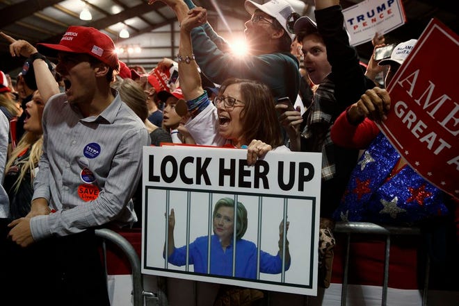In this Monday, Nov. 7, 2016 file photo, supporters of Republican presidential candidate Donald Trump, one holding a sign that reads, "LOCK HER UP," cheer during a campaign rally in Leesburg, Va. Trump, the president-elect, is calling for unity in words that draw attention precisely because they sound so unlike Trump, the candidate. But many question whether it is possible to reverse the campaign's damage to political discourse and its ripples out to the way Americans speak to and about each other. (AP Photo/ Evan Vucci)
