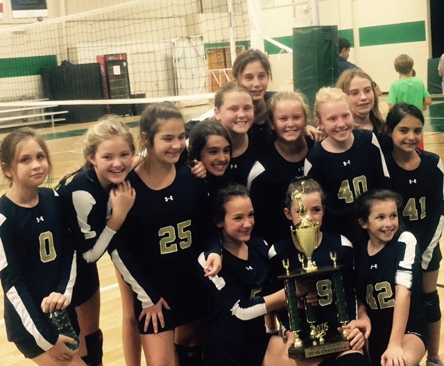 The Lady Rams of the St. Peter the Apostle sixth-grade volleyball team pose with their trophy after their two-set sweep of rival Hancock in the postseason tournament finals. (Courtesy of John Moore)