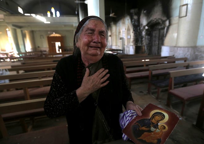 A Christian Iraqi woman cries after she saw the St. Addai church which was damaged by Islamic State fighters during their occupation of Keramlis village, less than 18 miles, 29 kilometers, southeast of Mosul, Iraq, Sunday Nov. 13, 2016. There were gasps, and then tears, at the small church in northern Iraq as a group of Christians returned to their parish to find everything had been destroyed, including the statue of the Virgin Mary which IS militants decapitated before they left. The church bell tolled for the first time in more than two years, but few can summon up hope for the future. (AP Photo/Hussein Malla)
