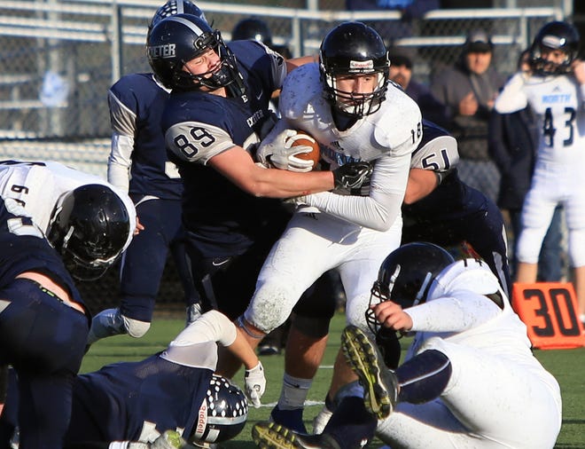 Exeter High School linebacker Bobby Cliche (89) brings down Nashua North ball carrier Levi Gosselin during Saturday's Division I playoff game in Exeter. Photo by Ioanna Raptis/Seacoastonline