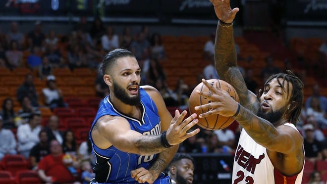 Orlando Magic guard Evan Fournier (10) attempts to save the ball from going out of bounds as Miami Heat forward Derrick Williams (22) makes a block during the first half of an NBA preseason basketball game, Tuesday, Oct. 18, 2016, in Miami. (AP Photo/Wilfredo Lee)
