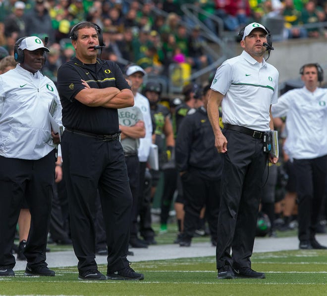 Oregon head coach Mark Helfrich and defensive coordinator Brady Hoke (left) had few answers for the Cardinal Saturday. (Brian Davies/The Register-Guard)