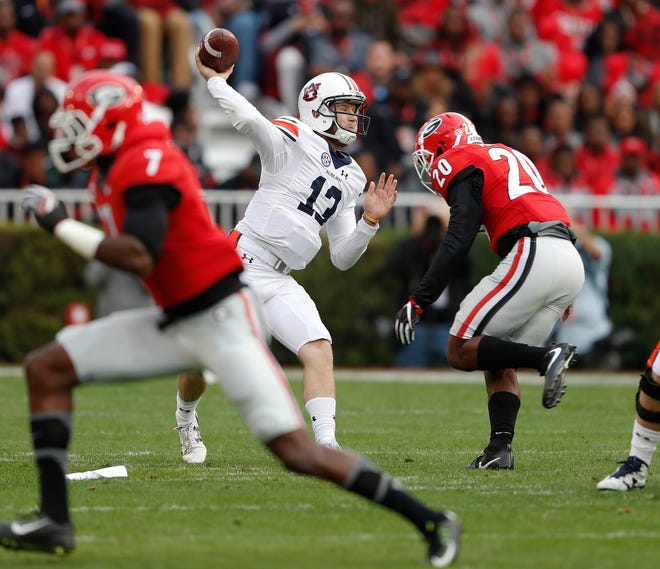 Auburn quarterback Sean White (13) throws under pressure from Georgia safety Quincy Mauger (20) in the first half of Saturday in Athens, Ga. The Bulldogs are now bowl eligible after knocking off the Tigers 13-7. (AP Photo/John Bazemore)