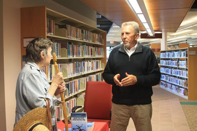 Gladys Harvey of Adel (left) and Tom Person talk about Person's books. Six authors from Adel gathered at the Adel Public Library for the Adel Author Fair on Thursday, Nov. 10.