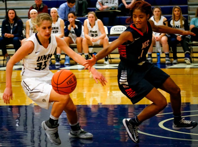 New Hampshire's Caroline Soucy , left, and New England College's Marjani Lillard battle for a loose ball during Monday's college basketball game at Lundholm Gymnasium in Durham. Photo by Shawn St. Hilaire/Fosters.com