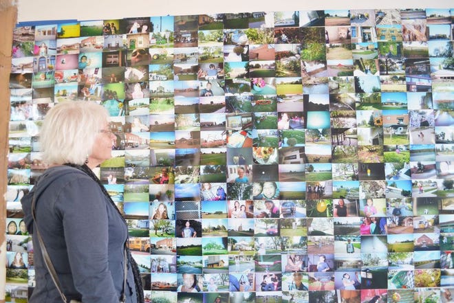 A photography exhibit at Citizens State Bank Building, comprised of photos taken by Perry's fifth grade students, is admired by Denise LaBorde. It was one of many exhibits offered by Art on the Prairie 2016.