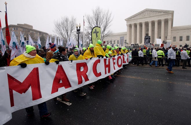 FILE - In this Jan. 22, 2016, file photo, marchers carry a banner during the March for Life 2016, in front of the U.S. Supreme Court in Washington, during the annual rally on the anniversary of 1973 ‘Roe v. Wade’ U.S. Supreme Court decision legalizing abortion. Roe v. Wade could be in jeopardy under Donald Trump’s presidency. If a reconfigured high court did overturn it, the likely outcome would be a patchwork: some states protecting abortion access, others enacting tough bans, and many struggling over what new limits they might impose. (AP Photo/Alex Brandon, File)