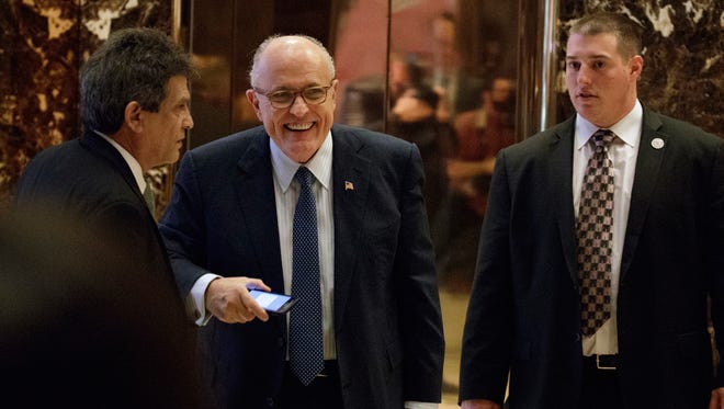 Former New York Mayor Rudy Giuliani, center, smiles as he leaves Trump Tower, Friday, Nov. 11, 2016, in New York. (AP Photo/Evan Vucci)