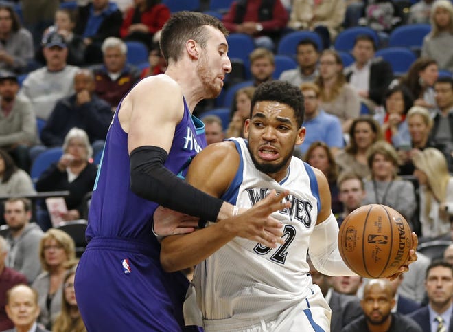 Minnesota's Karl-Anthony Towns, right, drives around Charlotte's Frank Kaminsky III in the first quarter of Tuesday's game in Minneapolis. (AP photo/Jim Mone)