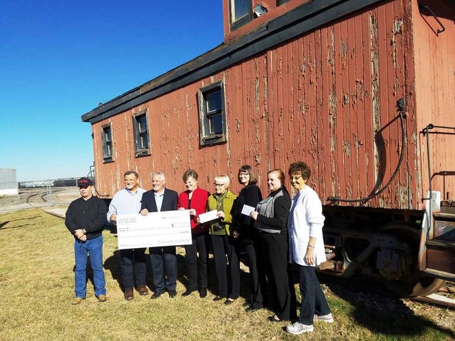 (Left to right) Barry Wicker, Mark Meurer, Stephen Warren, Sue Jones, Pam Brink, Deborah Pickens, Jessica Kelly and Sue Davis pose with their checks after being presented with the grant money from Warren, president of the Community Foundation of West Texas, on Tuesday in front of the Slaton Harvey House. The money was presented to the historical agency representatives for their work on upcoming historic preservation projects. The funding was made possible by the E. Jay Matsler Trust for Historic Preservation.
