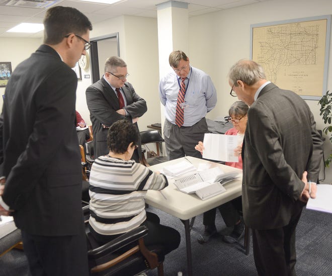 Jack Haley/Messenger Post Media

Heading into Tuesday's absentee count, Democrat Brian Dennis (middle right) was leading Republican Terence Robinson Jr. (left) by 139 votes for Ontario County Court judge. The ballots were being counted at the Ontario County Board of Elections.