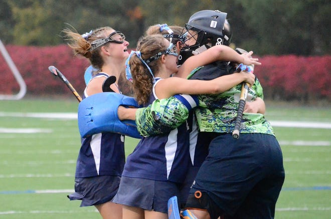 Exeter High School senior Kate Pigsley (far right) is mobbed by teammates after the Blue Hawks defeated Bishop Guertin, 3-2, in the first round of the Division I field hockey tournament last month. Pigsley was named Division I Player of the Year by the NHFHCA Tuesday morning. Photo by Ryan O'Leary/Seacoastonline