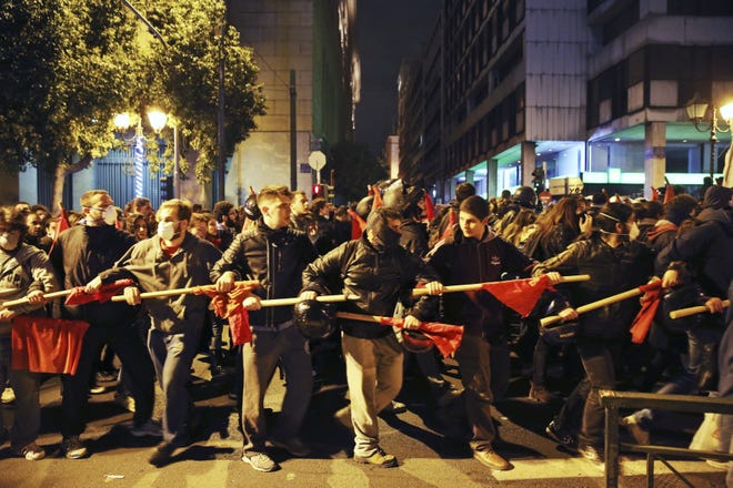 Demonstrators hold their ranks during a protest against the visit of US President Barack Obama in Athens, Tuesday, Nov. 15, 2016. Greek riot police used tear gas and stun grenades in central Athens Tuesday to disperse about 3,000 left-wing marchers after they tried to enter an area declared off-limits to demonstrators.