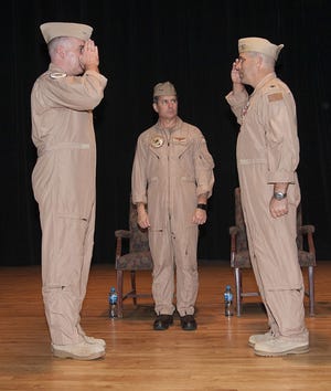 Capt. Christopher Flaherty (left) salutes Capt. Brett Coffey (right) during U.S. Naval Forces Central Command's (NAVCENT) maritime patrol force, commander, Task Force (CTF) 57 change of command, officiated by Vice Adm. Kevin Donegan, commander of NAVCENT (center), at Naval Support Activity Bahrain, Nov. 8.