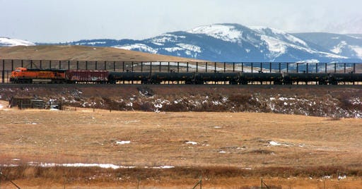 FIILE - In this Nov. 7, 2013, file photo, a train hauls oil into Glacier National Park near the Badger-Two Medicine National Forest in northwest Montana. U.S. officials said they've canceled 15 oil and gas leases in an area bordering Glacier National Park that's considered sacred to the Blackfoot tribes of the U.S. and Canada. Interior Secretary Sally Jewell said the Wednesday, Nov. 16, 2016, move will preserve the 130,000-acre Badger-Two Medicine area within the Lewis and Clark National Forest. The Badger-Two Medicine is the site of the creation story for members of Montana's Blackfeet Nation and the Blackfoot tribes of Canada. (AP Photo/Matthew Brown, File)