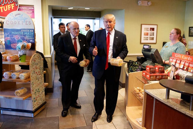 FILE - In this Oct. 10, 2016, file photo, former New York mayor Rudy Giuliani, left, stands with then-Republican presidential candidate Donald Trump as he buys cookies during a visit to Eat'n Park restaurant in Moon Township, Pa. Will President-elect Trump remake school lunches into his fast-food favorites of burgers and fried chicken? Children grumbling about healthier school meal rules championed by first lady Michelle Obama may have reason to cheer Trump's election. The billionaire businessman is a proud patron of quick food restaurants and is promising to curb federal regulations. (AP Photo/Evan Vucci, File)
