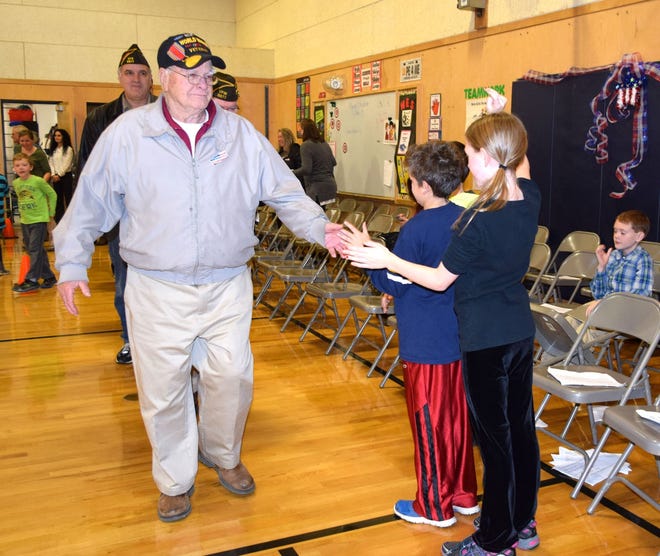 Photo by Reg Bennett

World War II Veteran John Primerano greets students at the end of the Veterans K-4 assembly at Wells Elementary School on November 10. Behind Primerano is Roger LaPlante, a U.S. Air Force veteran.