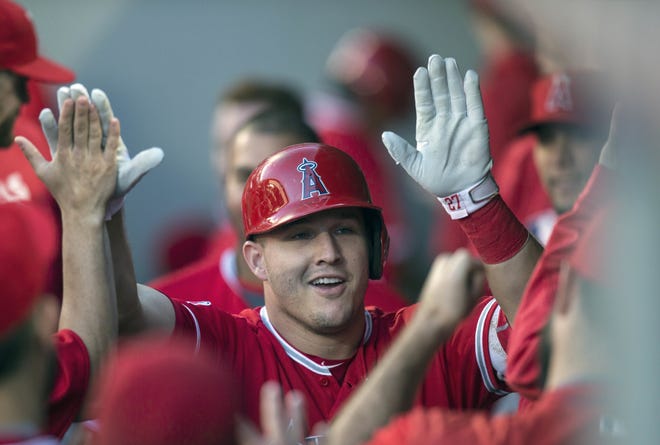 Los Angeles Angels' Mike Trout is congratulated by teammates after hitting a solo home run off Seattle Mariners starter Taijuan Walker during the first inning of a game in Seattle on Sept. 3. Trout was named the American League's MVP on Thursday. (AP Photo/Stephen Brashear, File)