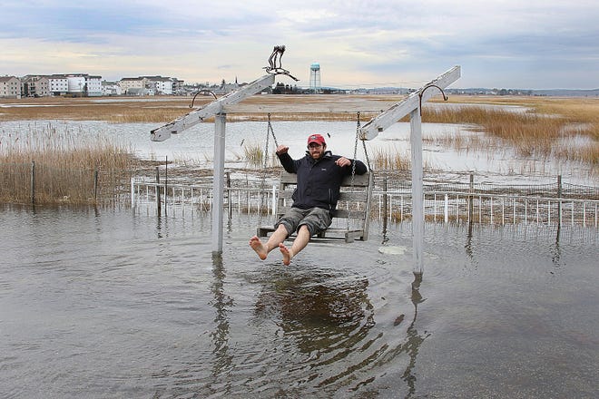 Kyle Heavey puts down the camera to swing over a flooded backyard along Ocean Boulevard at Hampton Beach during an astronomical high tide on Tuesday following the supermoon.

Photo by Rich Beauchesne/Seacoastonline