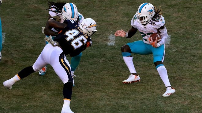 SAN DIEGO, CA - NOVEMBER 13: Jay Ajayi #23 of the Miami Dolphins avoids the tackle of Chris Landrum #46 of the San Diego Chargers during the second half of a game at Qualcomm Stadium on November 13, 2016 in San Diego, California. (Photo by Sean M. Haffey/Getty Images)