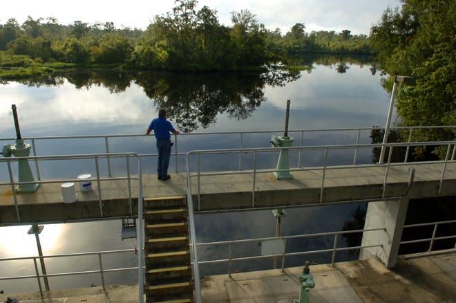 An employee of the Peace River-Manasota Regional Water Supply Authority stands on the river intake structure trhough which millions of gallons a day can be skimmed from the Peace River and stored.  The facility is near Fort Ogden in DeSoto County. (Herald-Tribune Archive)