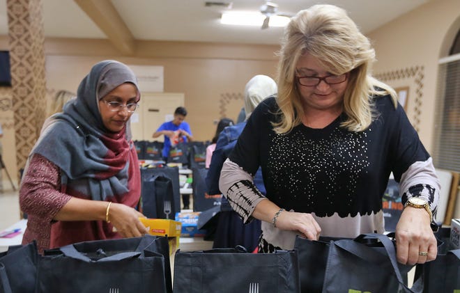 Rifat Fatema works with Candy Al-Khateeb to fill bags with groceries for food-insecure Bozeman students on Wednesday at the Bay County Islamic Society. PATTI BLAKE/THE NEWS HERALD