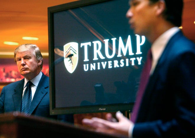 FILE- In this May 23, 2005 file photo, then real estate mogul and Reality TV star Donald Trump, left, listens as Michael Sexton introduces him at a news conference in New York where he announced the establishment of Trump University. A federal judge in San Diego will consider arguments on President-elect Trump’s latest request to delay a civil fraud trial involving his now-defunct Trump University until after his inauguration on Jan. 20, 2017. Trump’s attorneys said in a court filing ahead of the hearing, Friday, Nov. 18, 2016, that preparations for the White House were “critical and all-consuming.” (AP Photo/Bebeto Matthews, File)