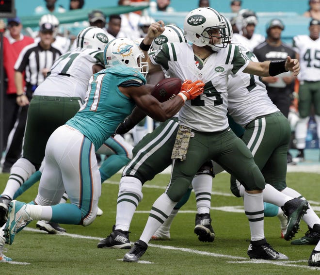 Miami Dolphins defensive end Cameron Wake (91) sacks New York Jets quarterback Ryan Fitzpatrick (14), during the first half of a game on Nov. 6 in Miami Gardens. (AP Photo/Wilfredo Lee)