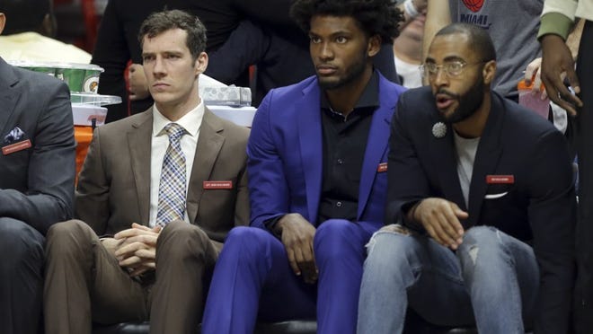 Miami Heat guard Goran Dragic, left, and forward Justise Winslow, center, watch from the bench during the first half of an NBA basketball game against the Atlanta Hawks, Tuesday, Nov. 15, 2016, in Miami. Tragic has a sprained ankle and Winslow has a sprained wrist. (AP Photo/Lynne Sladky)