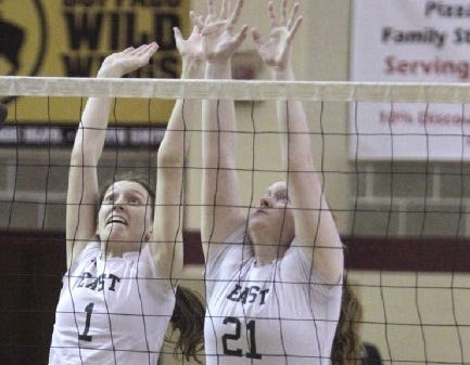 Hannah Mason and (21) Victoria Bowry leap to block a spike in Wednesday's semifinal game against Juanita Sanchez. On Saturday, East beat Scituate for the Division II crown.