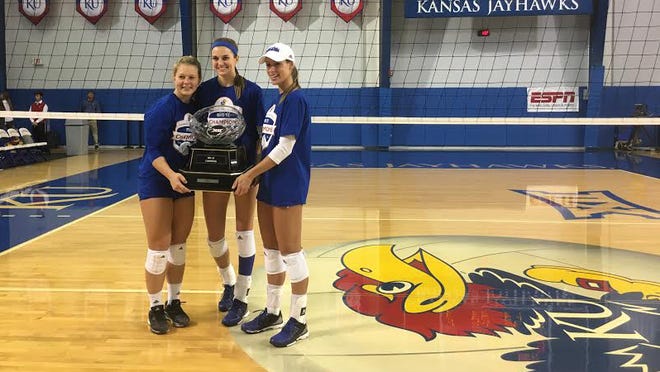 Kansas volleyball seniors, from left, Cassie Wait, Tayler Soucie and Maggie Anderson hold the Big 12 trophy after clinching at least a share of the conference championship with a five-set victory over Iowa State on Saturday at Horejsi Family Athletics Center in Lawrence. (Photo by Scott Chasen/The Capital-Journal)