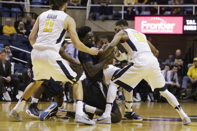 New Hampshire forward Iba Camara (12) and West Virginia guard Tarik Phillip battle for a loose ball during the first half of Sunday's game in Morgantown, W.Va. No. 19 West Virginia won 100-41. AP Photo