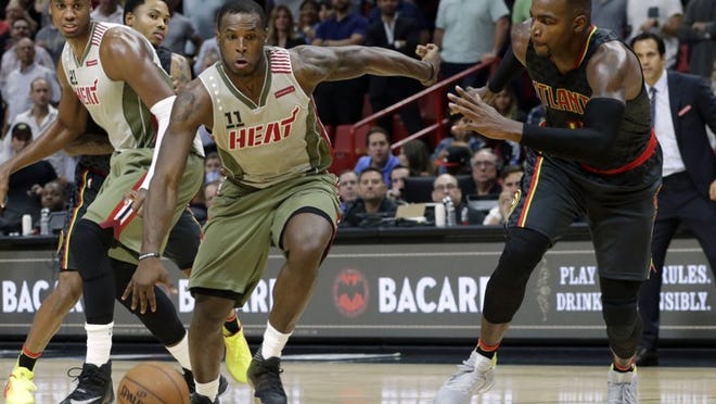 Miami Heat guard Dion Waiters (11) brings the ball down the court as Atlanta Hawks forward Paul Millsap, right, defends during the second half of an NBA basketball game, Tuesday, Nov. 15, 2016, in Miami. The Hawks defeated the Heat 93-90. (AP Photo/Lynne Sladky)