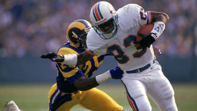 ANAHEIM, CA - DECEMBER 14: Wide receiver Mark Clayton #83 of the Miami Dolphins tries to break a tackle by defensive back Jerry Gray #25 of the Los Angeles Rams during a game at Anaheim Stadium on December 14, 1986 in Anaheim, California. The Dolphins won 37-31 in overtime. (Photo by George Rose/Getty Images)