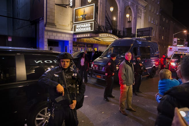 Heavily armed police stand guard as a motorcade carrying Vice President-elect Mike Pence, center, leaves the Richard Rodgers Theatre after a performance of "Hamilton," in New York, Friday. (AP Photo/Andres Kudacki)