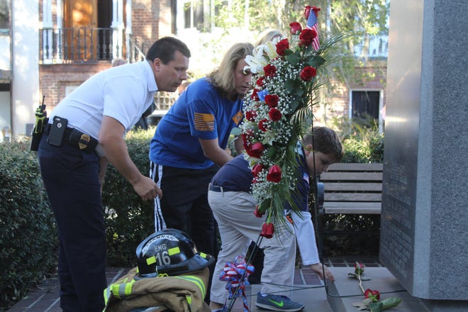 Cole Curry, 8, places a rose at the foot of the firefighter memorial in front of Savannah Fire and EMS headquarters in honor of his father, Master Firefighter Michael Curry, on Sunday at the Firefighters Memorial Service. Michael Curry died Saturday. (Photos by Will Peebles/SMN)