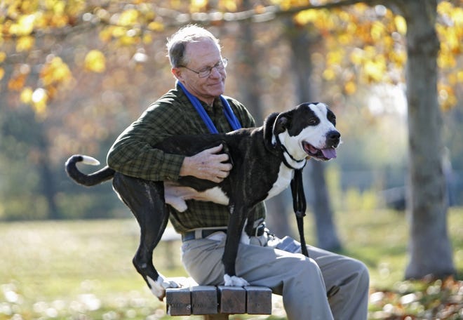 Franklin County Dog Shelter adoption counselor Reid Thompson and pit bull Hitchcock take a break from taking their exercise.