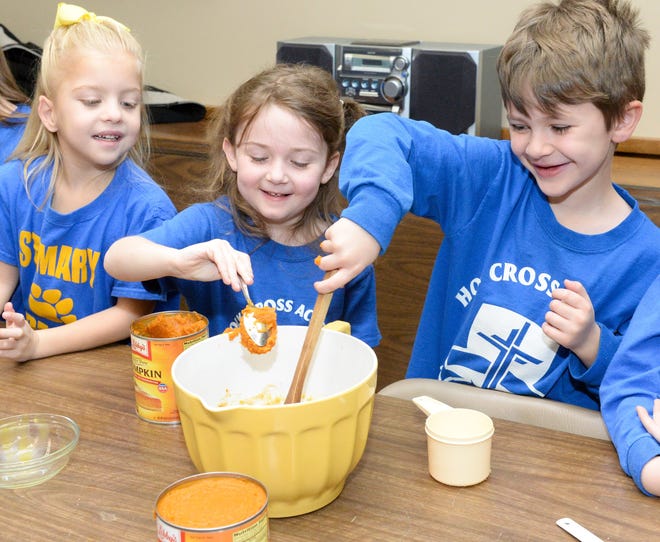 Ellie Spicocchi (left to right) Emerson Dudley and Caleb Paul make pumpkin pies at St Mary's School in Massillon Monday. Approximately 130 kindergarten parents were to join their children Monday evening for a Thanksgiving prayer service and potluck meal. (Cantonrep.com / Michael Balash)