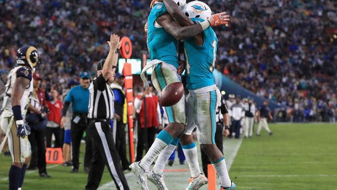 LOS ANGELES, CA - NOVEMBER 20: DeVante Parker #11 of the Miami Dolphins celebrates his touchdown on a nine yard pass with teammate Jarvis Landry #14 late in the fourth quarter of the game against the Los Angeles Rams at Los Angeles Coliseum on November 20, 2016 in Los Angeles, California. The Dolphins won the game 14-10. (Photo by Sean M. Haffey/Getty Images)
