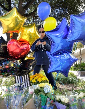 A woman leaves balloons at a make-shift memorial for slain San Antonio police officer Benjamin Marconi, 50, a 20-year veteran of the force, Monday, Nov. 21, 2016, in San Antonio. Marconi was fatally shot during a traffic stop near police headquarters Sunday. (AP Photo/Eric Gay)