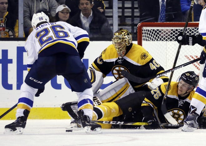 Bruins defenseman Brandon Carlo (right) drops down in front of goalie Tuukka Rask as they defend against Blues center Paul Stastny (left) in the second period of Boston's 4-2 loss on Tuesday night.