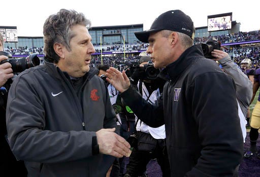 FILE - In this Nov. 27, 2015, file photo, Washington State coach Mike Leach, left, is greeted by Washington coach Chris Petersen after an NCAA college football game in Seattle. Rarely have both teams entered the Apple Cup with so much at stake. (AP Photo/Elaine Thompson, File)