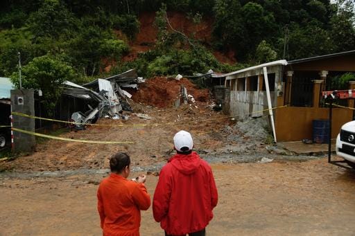 Civil Defense workers look the area where a couple was killed after their home was destroyed by a mudslide in Arraijan on the outskirts of Panama City, Tuesday, Nov. 22, 2016. Civil defense officials in Panama say the country has already seen three deaths blamed on late-season Tropical Storm Otto. (AP Photo/Arnulfo Franco)