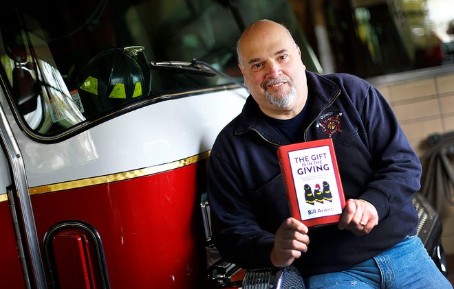 Retired Quincy fire fighter Bill Arienti with his just published book " The Gift is in the Giving" on Thursday Nov. 17, 2016
Greg Derr/The Patriot Ledger